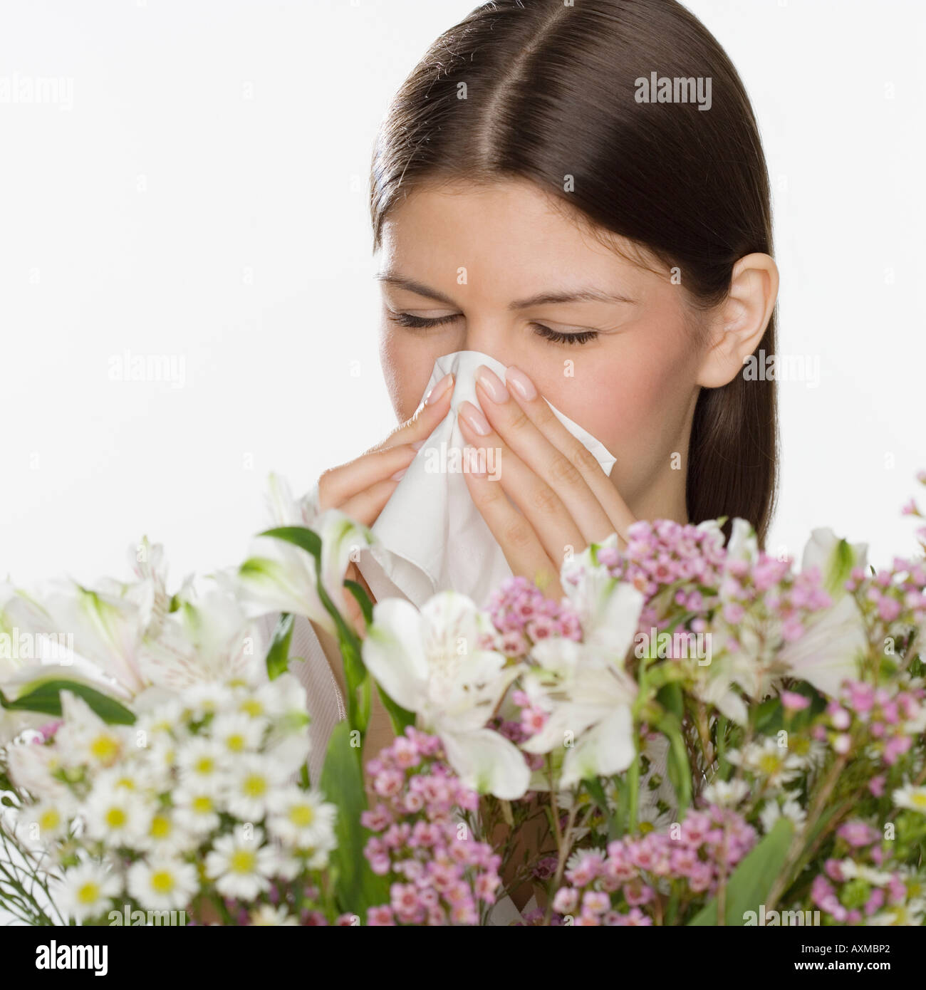 Woman blowing nose à côté de fleurs Banque D'Images