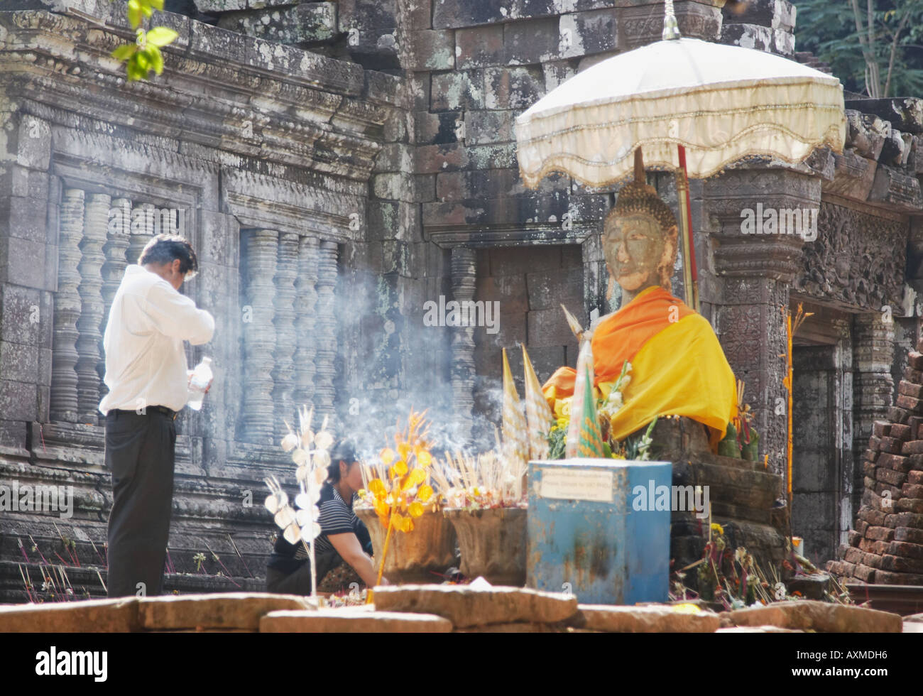 L'homme et la femme priant à Statue de Bouddha, Wat Phu Banque D'Images