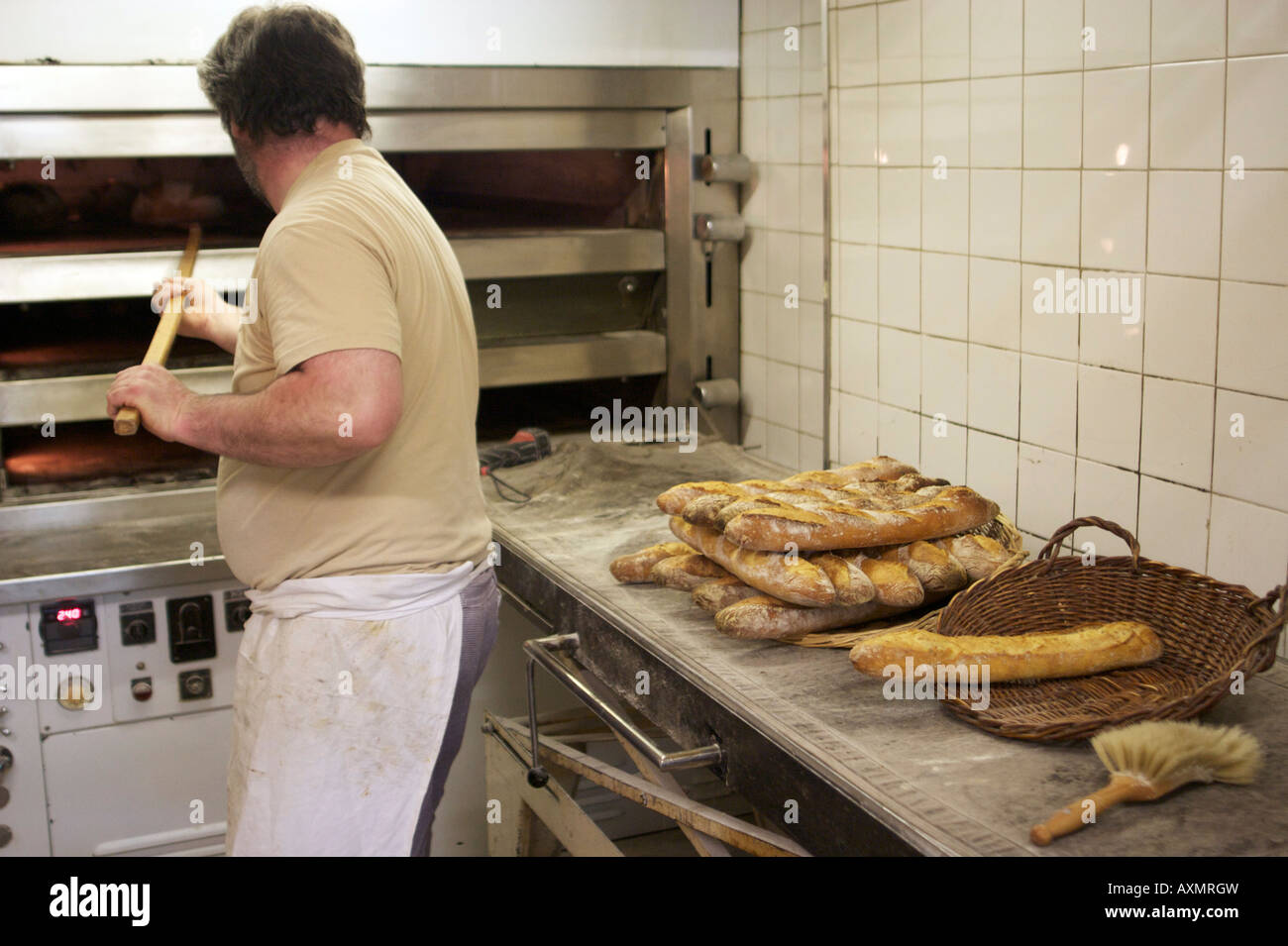 Baker Jacques Langlois de placer le pain dans son four à sa boulangerie de la rue Beauvoisine à Rouen, Seine-Maritime, France. Banque D'Images