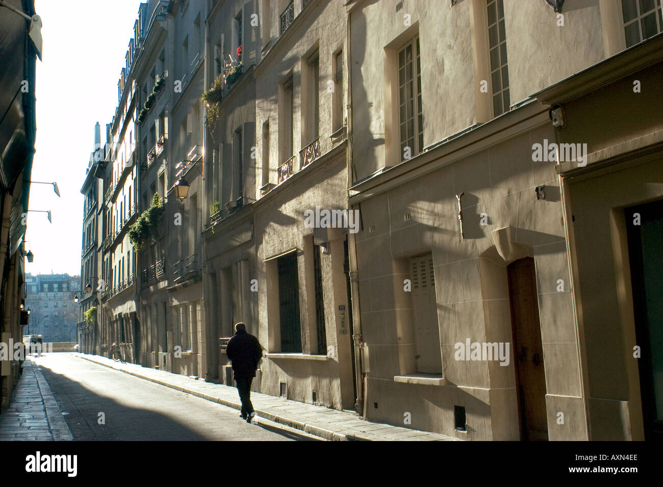 Paris france, french Street scene 'Ile St Louis' en rangée sur rue budé, l'homme marche loin, la lumière sur les façades Banque D'Images