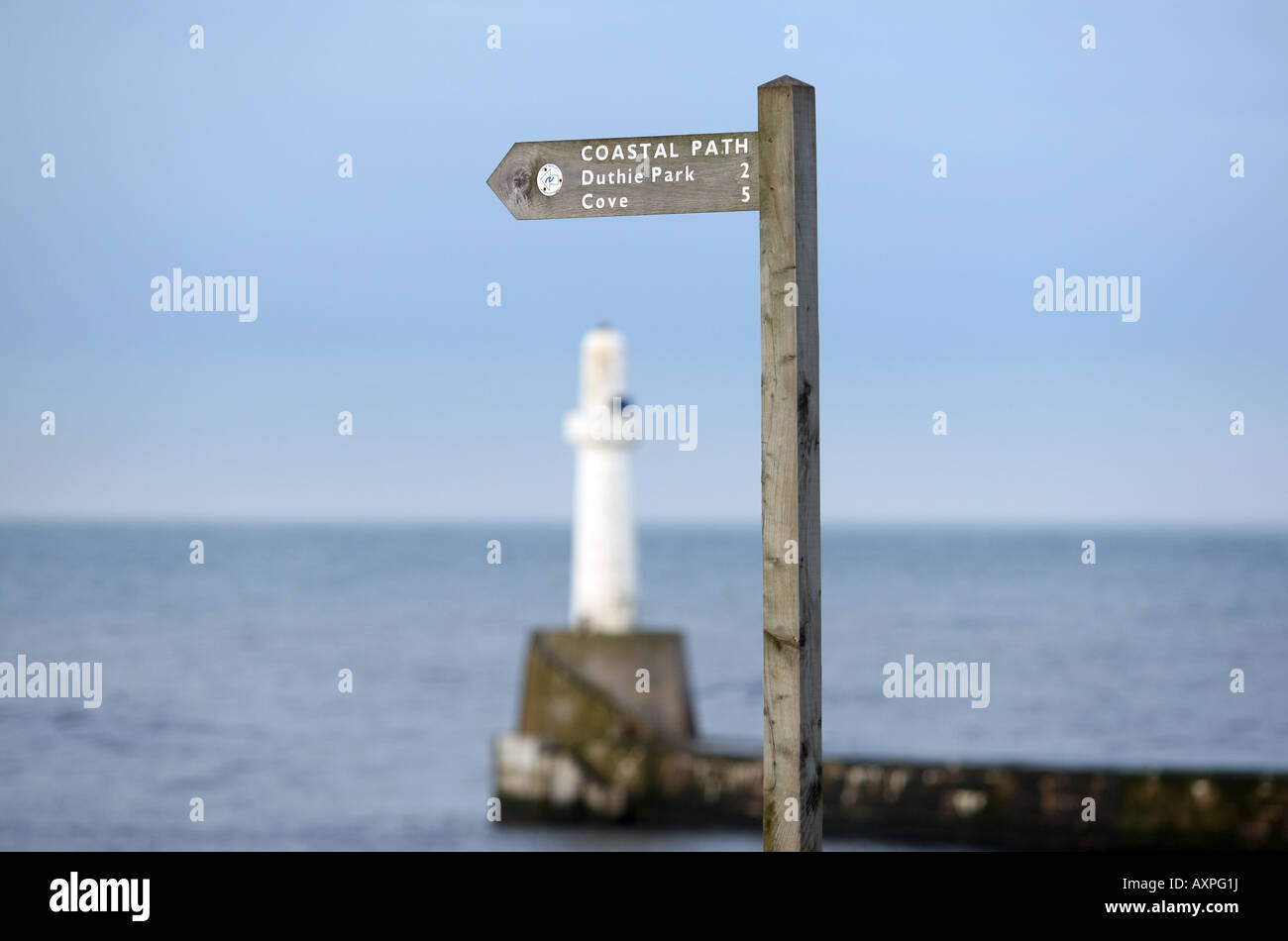 Panneau indiquant l'itinéraire du sentier côtier d'Aberdeen, Écosse, Royaume-Uni, avec la mer du nord et le phare en arrière-plan Banque D'Images