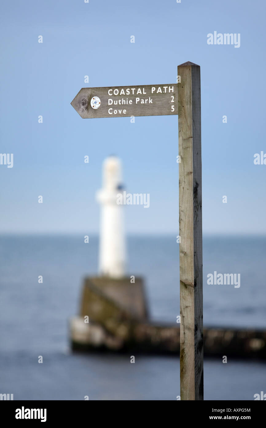 Panneau indiquant l'itinéraire du sentier côtier d'Aberdeen, Écosse, Royaume-Uni, avec la mer du nord et le phare en arrière-plan Banque D'Images