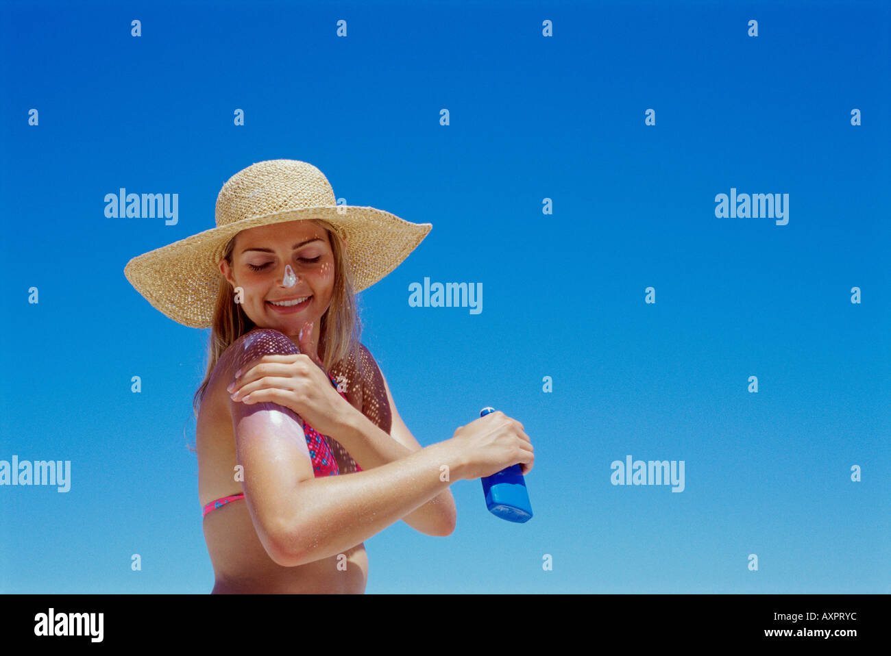 Portrait of a young woman applying lotion solaire sur son bras Banque D'Images