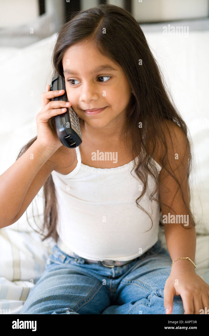 Jeune fille parlant au téléphone de s'asseoir à l'écart. Banque D'Images