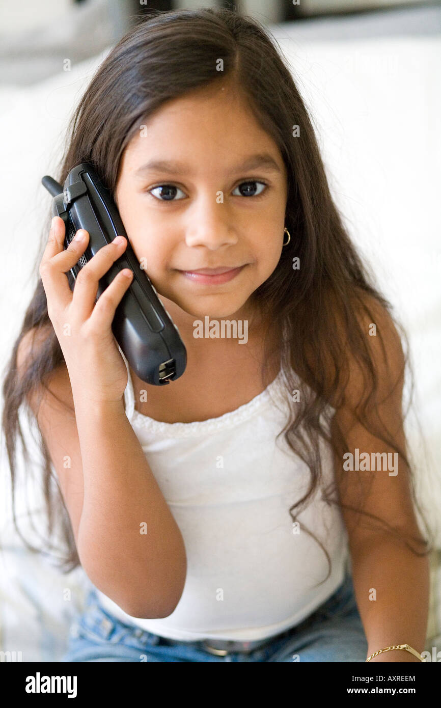 Young Girl holding phone à son oreille d'un contact visuel Banque D'Images