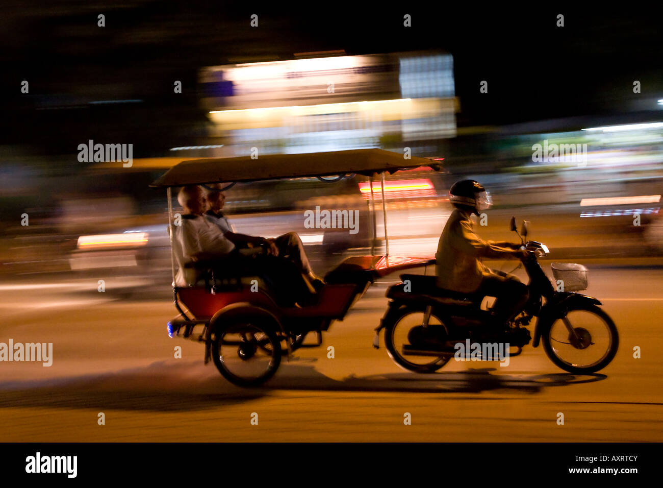 Une moto zooms passé tirant un rickshaw à Siem Reap, Cambodge Banque D'Images