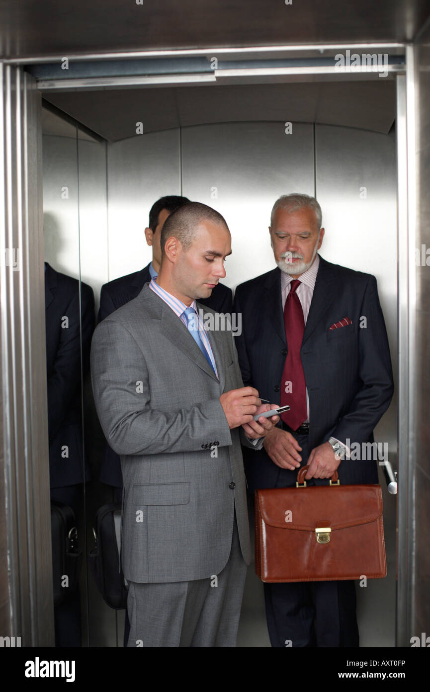 Trois hommes d'affaires dans un ascenseur Banque D'Images