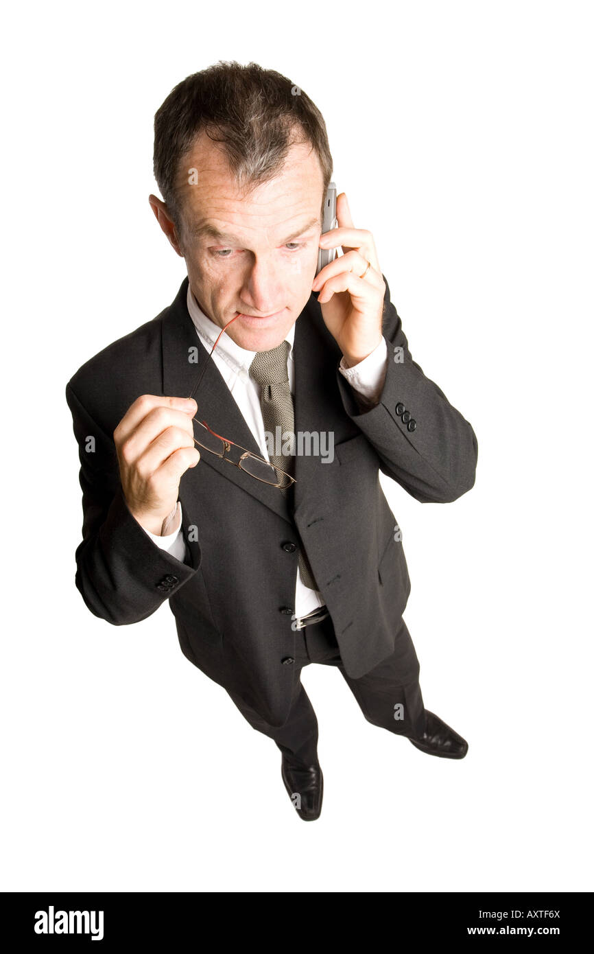Business man standing dans un costume noir est en train de parler sur un téléphone mobile pour expliquer quelque chose de sérieux. La vue est du haut vers le bas. Banque D'Images