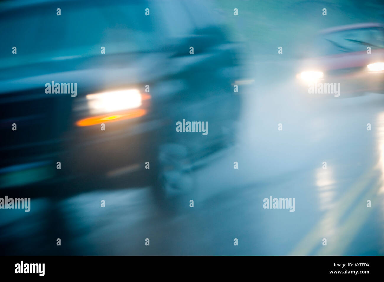 Blurred motion détail du trafic dans la pluie avec pulvériser de l'eau et de lumière qui se reflète sur la chaussée Banque D'Images