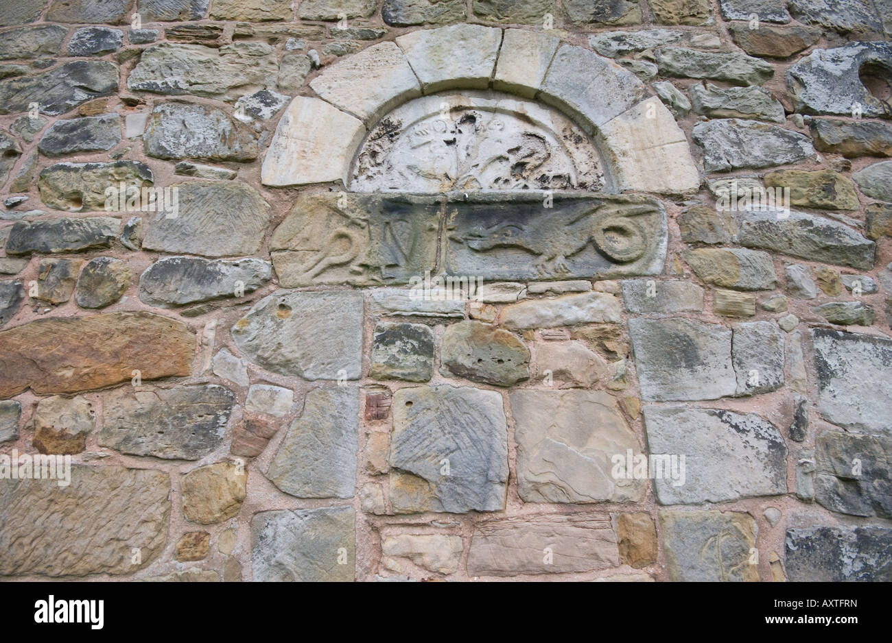 St Jean le Baptiste d'Ault Hucknall montrant la sculpture sur pierre de St George et le Dragon, séparés par une croix. Banque D'Images