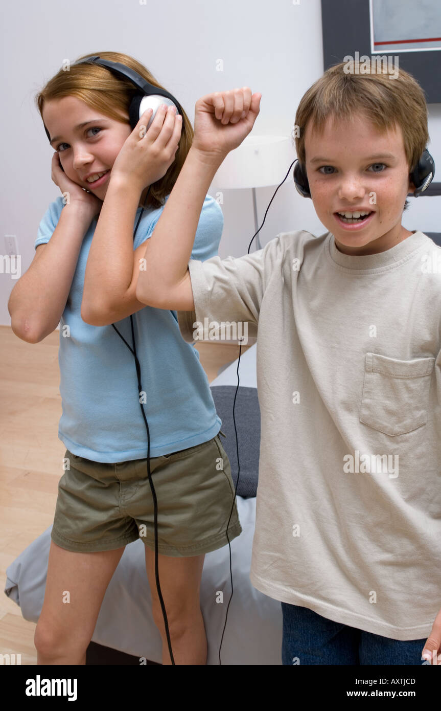 Portrait de deux jeunes enfants à l'écoute de casque en dansant. Banque D'Images