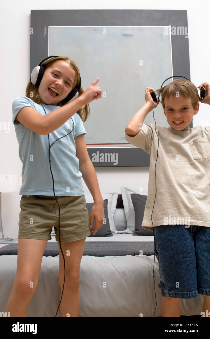 Portrait de deux jeunes enfants à l'écoute de casque en dansant. Banque D'Images