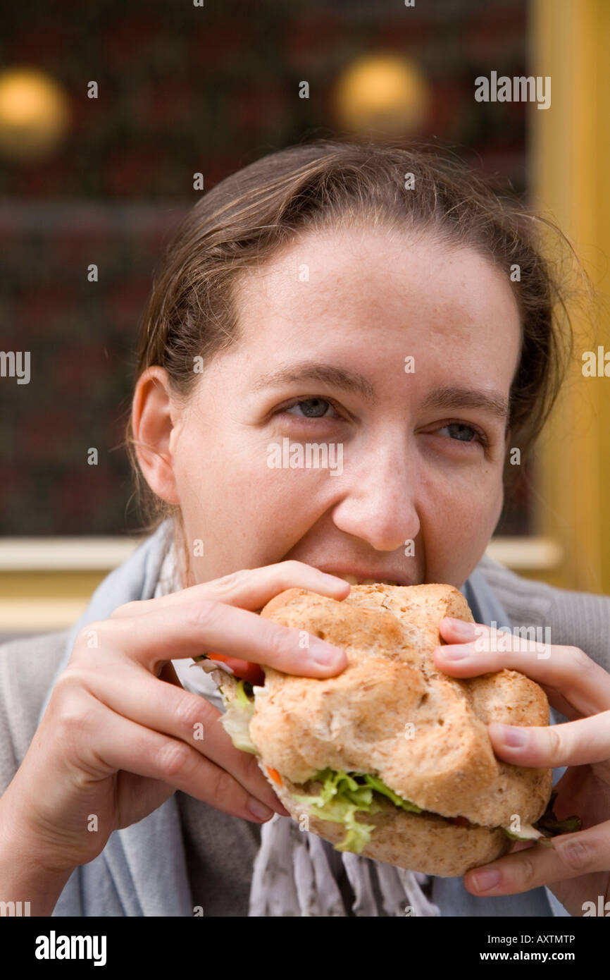 Femme mord dans un sandwich Banque D'Images