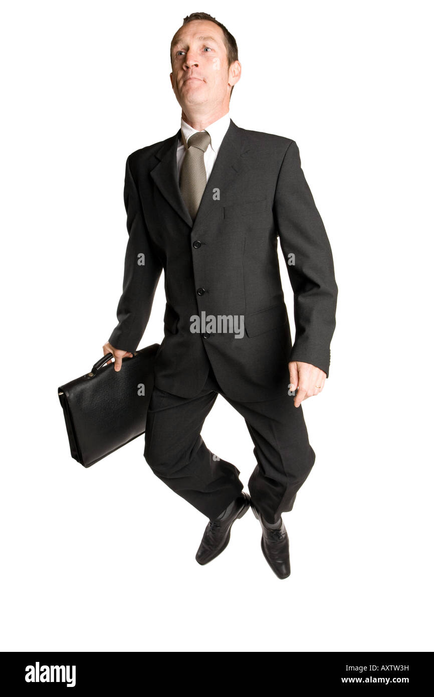 Homme d'affaires iin un fond blanc avec une valise saute dans un costume noir Banque D'Images