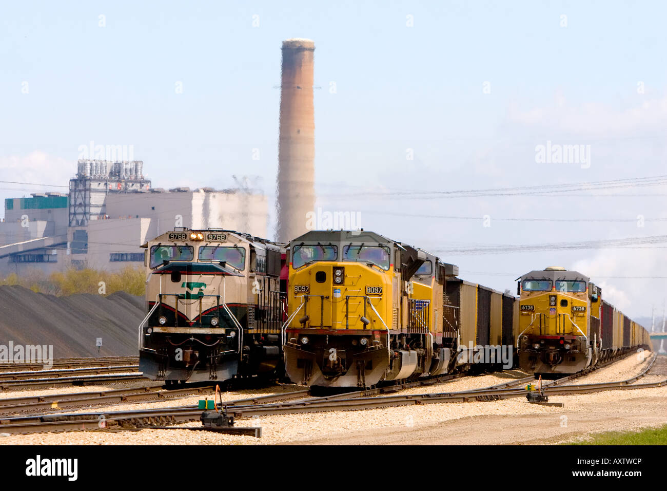 Trois trains de charbon en ligne tout en offrant du charbon pour la centrale électrique. Banque D'Images