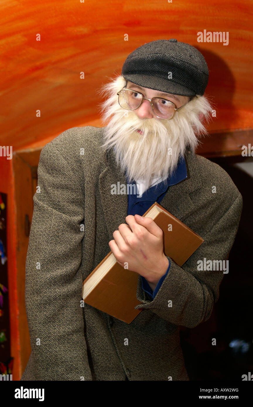 Vieil homme barbe blanche manteau gris livre tenir un retraité Retraité peur intérieur seul Banque D'Images