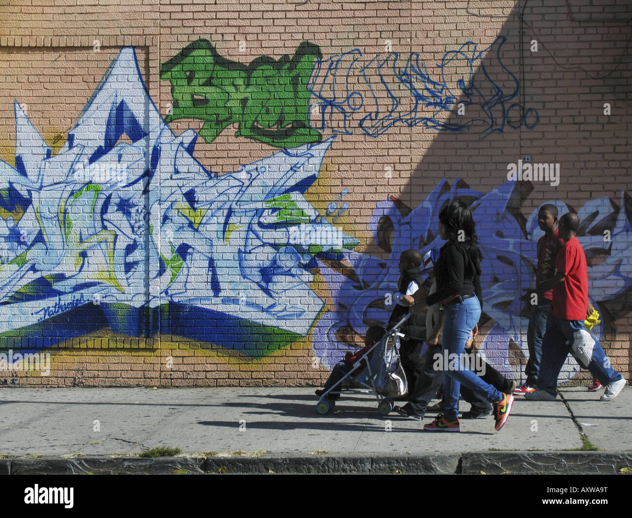 Les piétons en face de mur avec des graffitis colorés, Etats Unis, Bronx, New York Banque D'Images