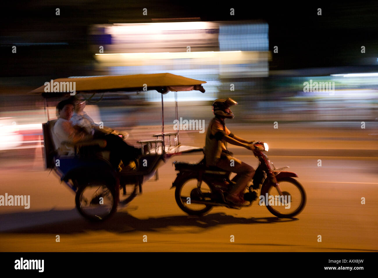 Un conducteur de pousse-pousse transporte 2 touristes à Siem Reap, Cambodge près d'Angkor Wat Banque D'Images