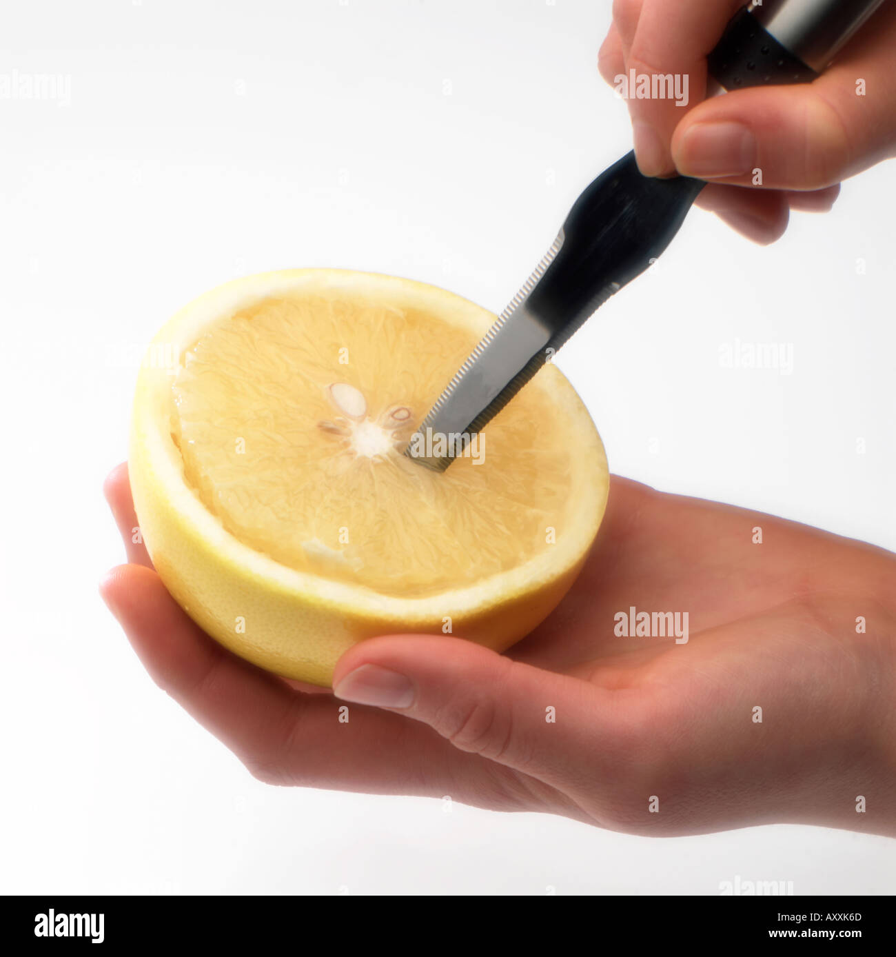 Préparer le pamplemousse a tenu dans la main avec le couteau Banque D'Images