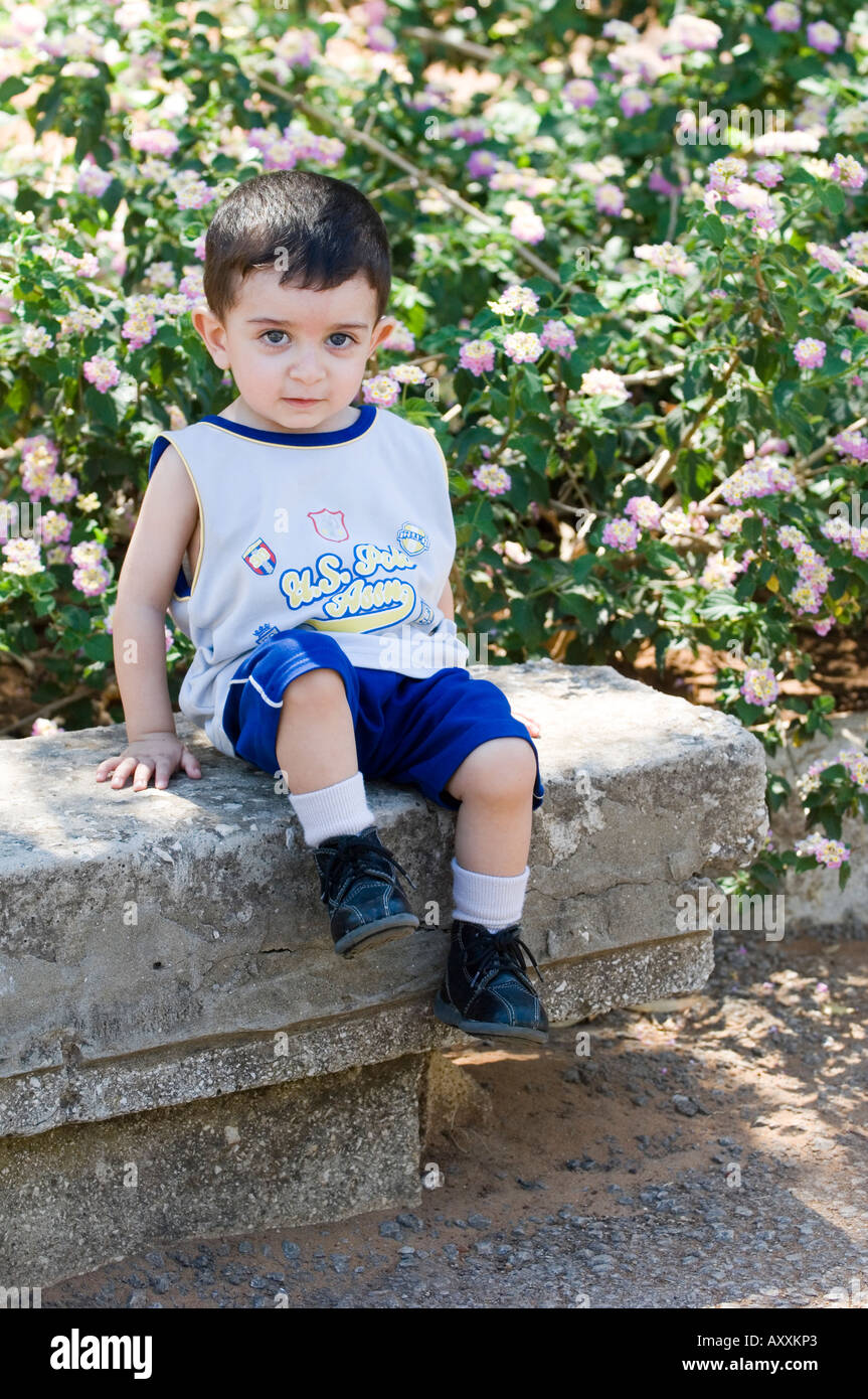 Mignon bébé assis à l'extérieur Banque D'Images