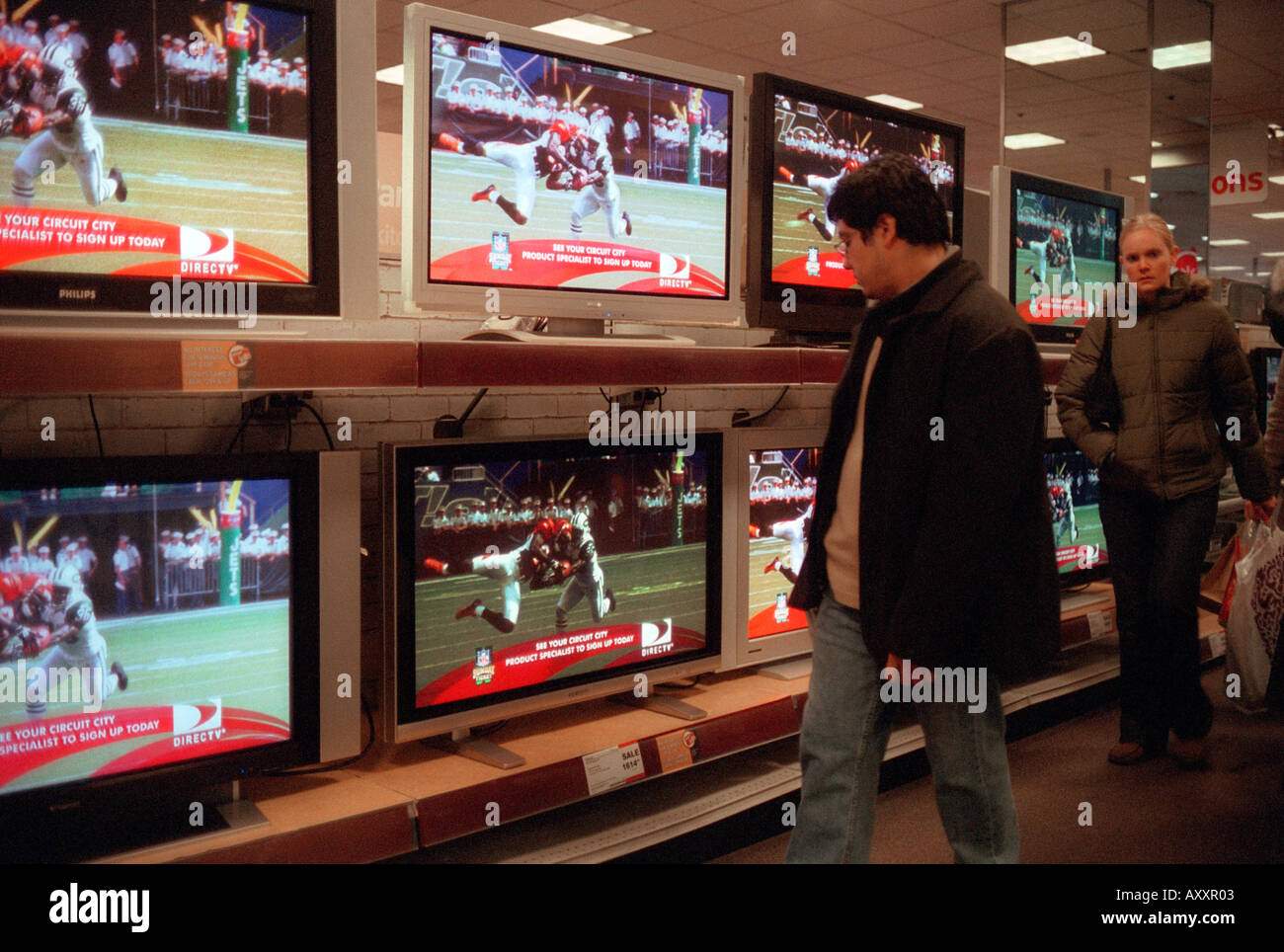 Un client d'électronique Circuit City à New York inspecte les téléviseurs haute définition Banque D'Images