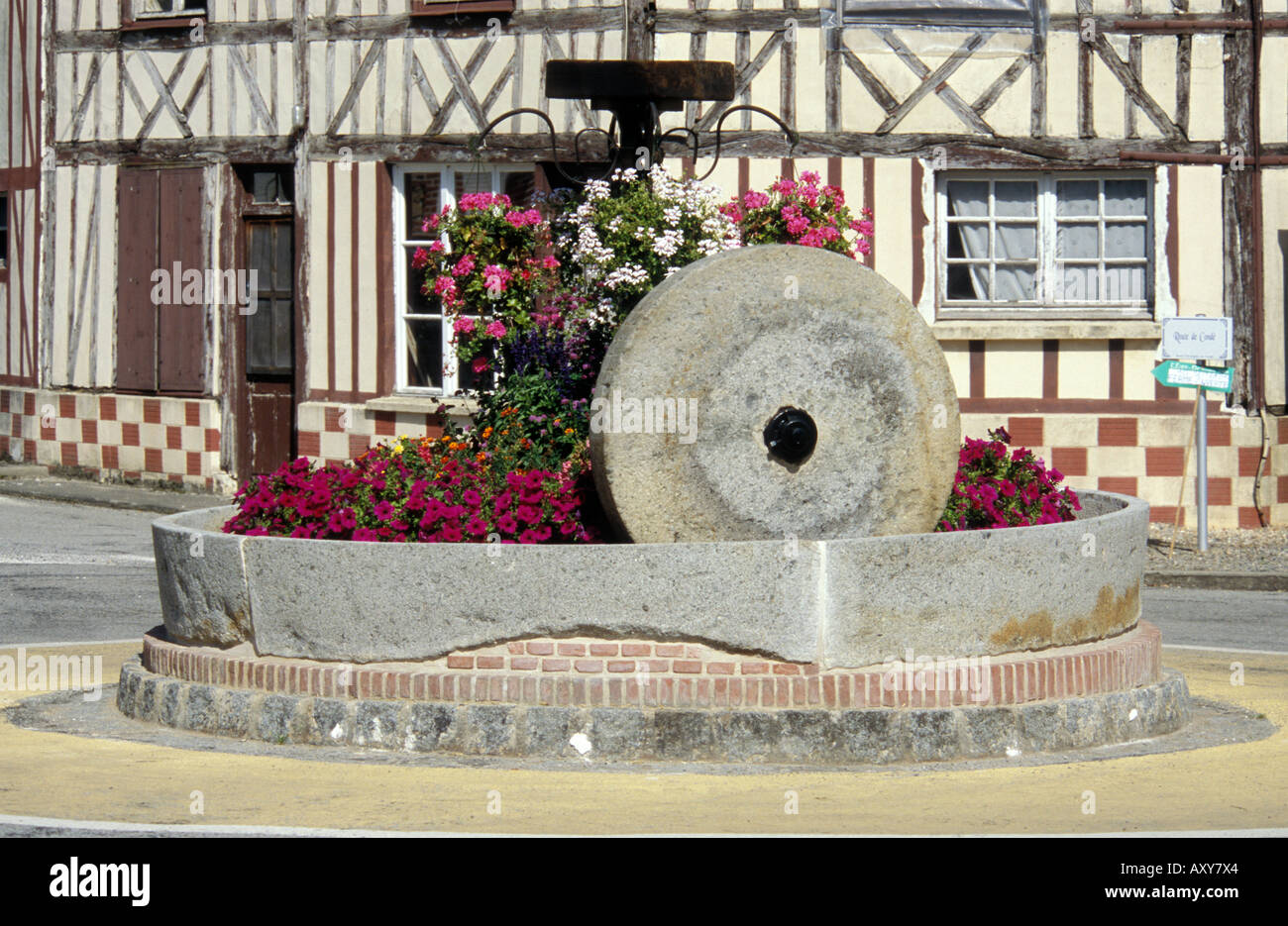 Saint Christophe sur Condé - Normandie - France vieille meule utilisée comme décoration rond-point Banque D'Images