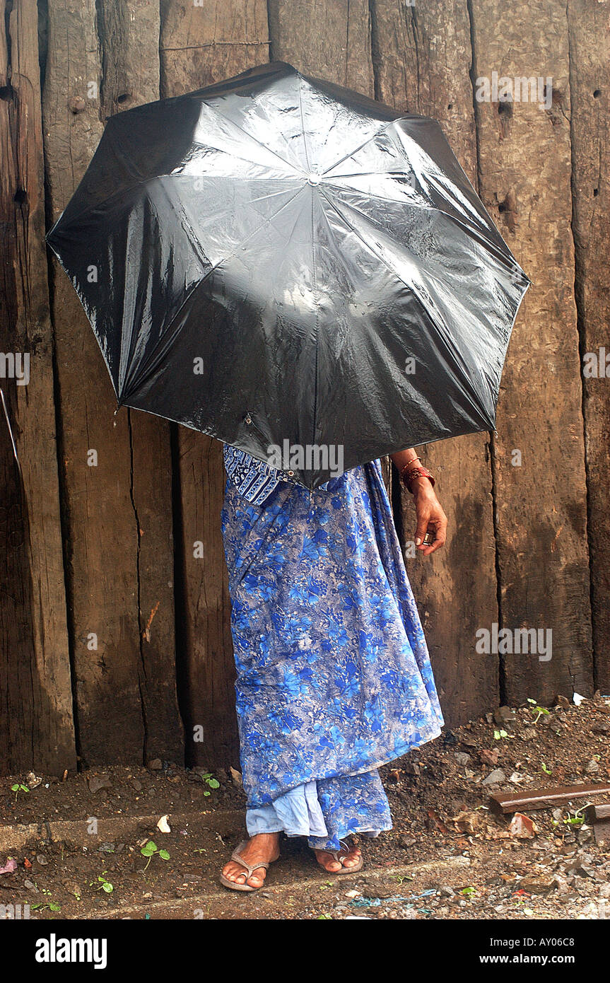 La PROTECTION D'UNE FEMME ELLE-MÊME DE LA PLUIE PRÈS DE GARE KURLA MUMBAI MAHARASHTRA INDE Banque D'Images