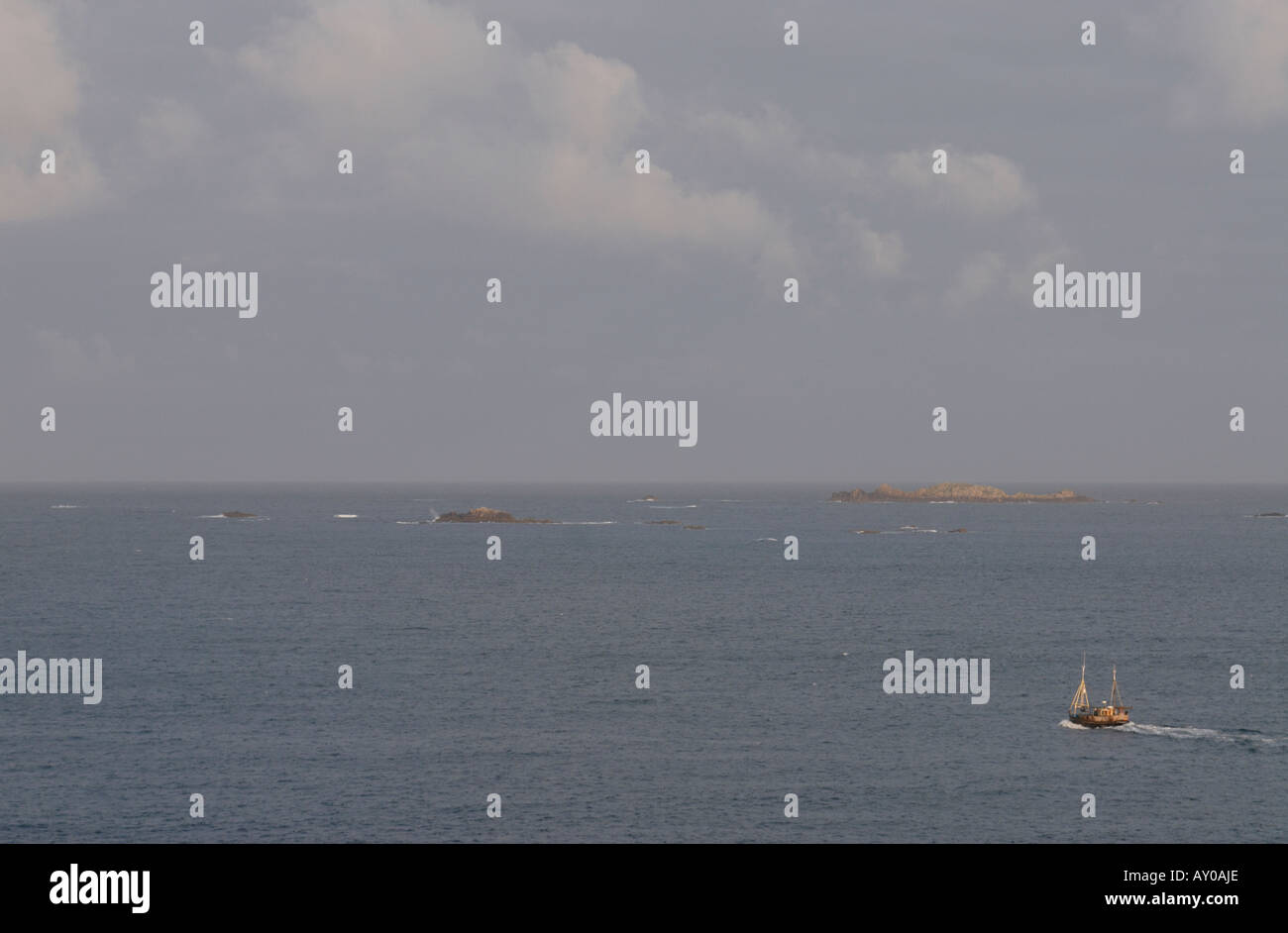 Un bateau de pêche se met en route de St Mary s vers un ciel orageux gris Banque D'Images