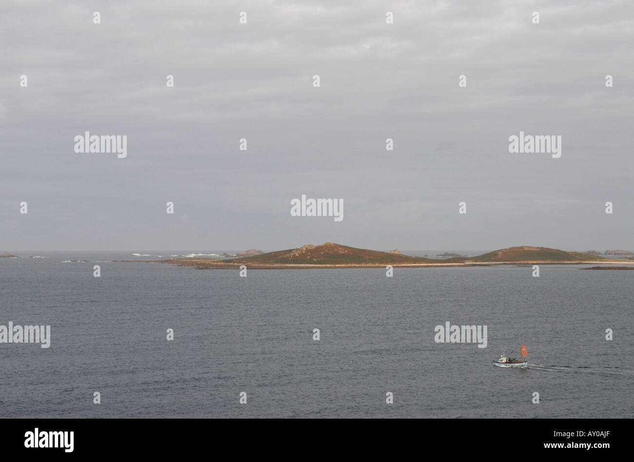 Un bateau de pêche se met en route de St Mary s vers un ciel orageux gris Banque D'Images