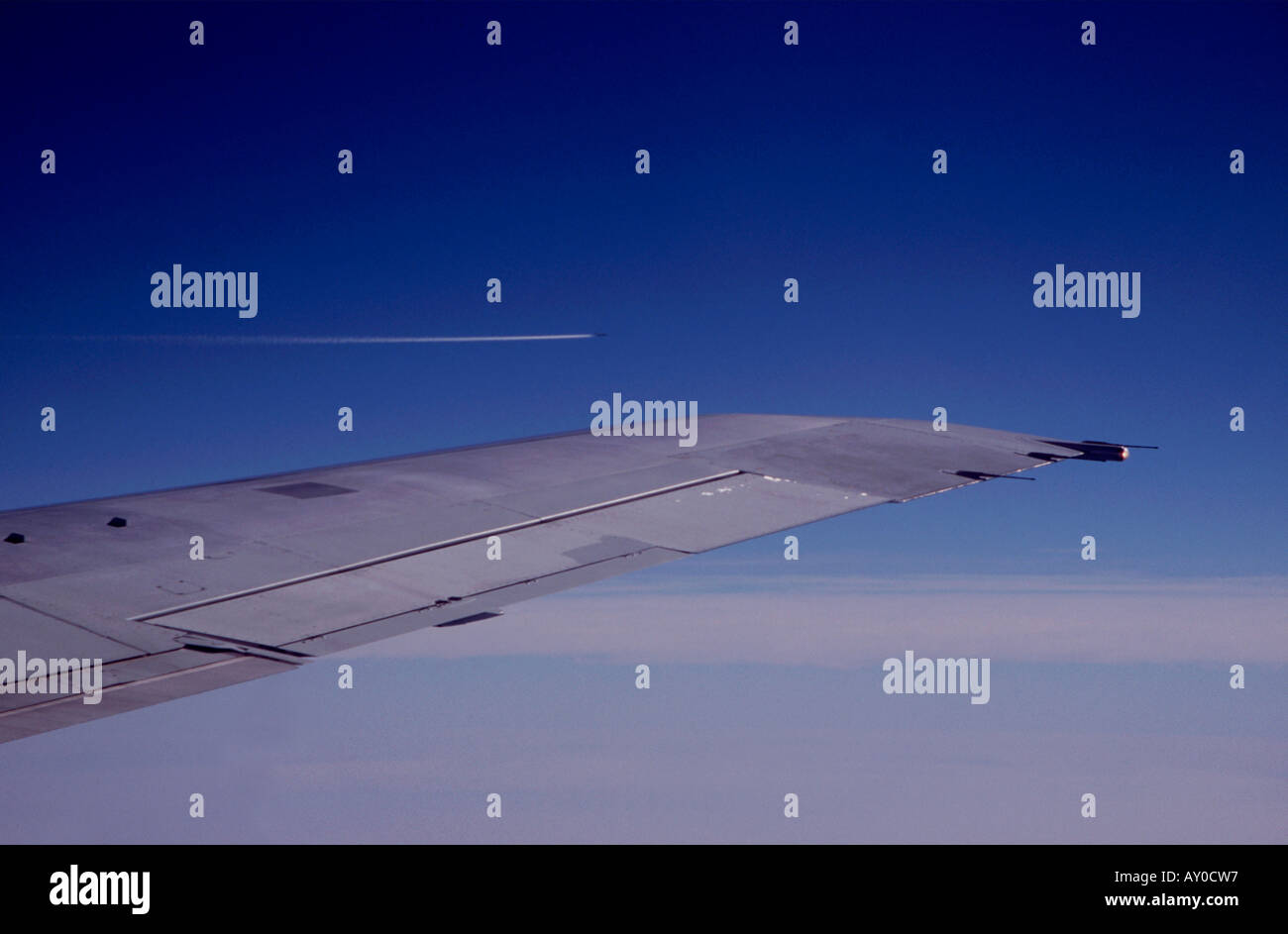 Vue à travers la fenêtre de l'avion de l'aile d'avion contre un ciel bleu profond Banque D'Images
