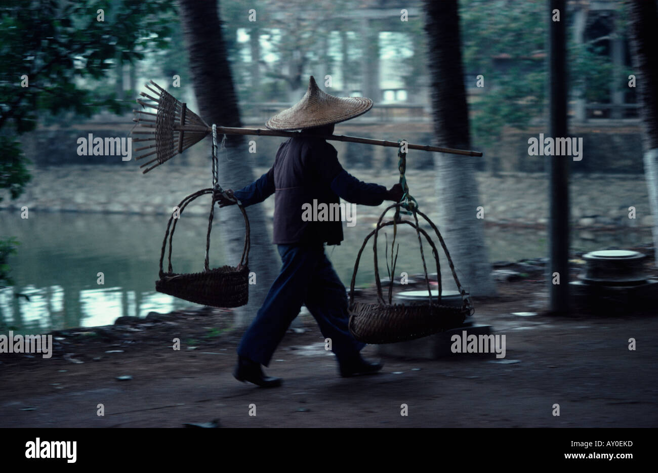 Travailleur chinois portant un large chapeau pointu reed pôle comptable avec deux paniers aux deux extrémités kwangchow chine fareast Asie Banque D'Images