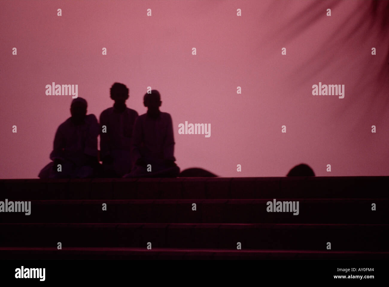 Silhouette de trois hommes en prière le long de la corniche de Djeddah Arabie saoudite Moyen-Orient Banque D'Images