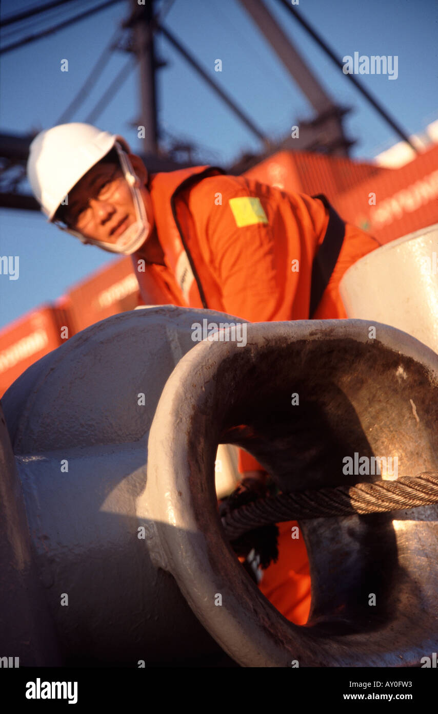Close up of face de tugboat worker holding prêts à passer la ligne d'amarrage jusqu'à porte-conteneurs à Kwai Chung hong kong port fareast Banque D'Images