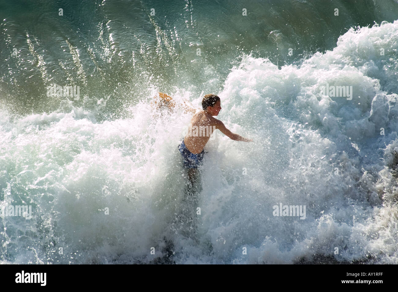 Boy in the surf embarquement écrémé Banque D'Images