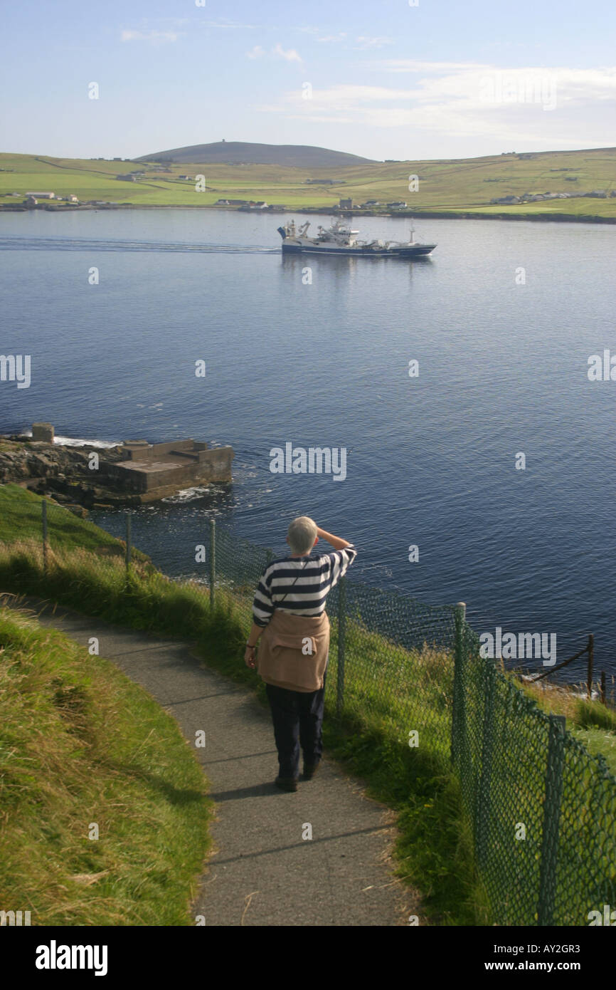 Une femme marche autour du Knab à Lerwick, Shetland Banque D'Images