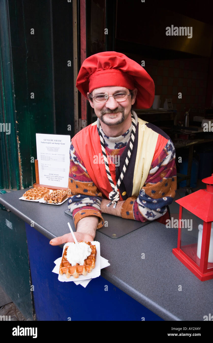 Vendeur de rue desservant une gaufre belge avec la crème fouettée, à Gand, en Belgique. Banque D'Images