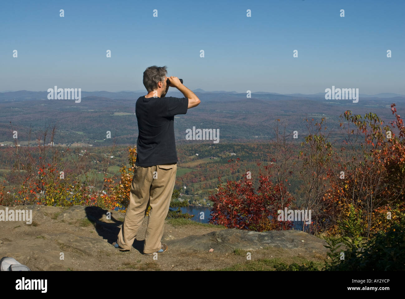 Mae hiker avec jumelles vue depuis le sommet du Mt. Elmore, Vermont Banque D'Images