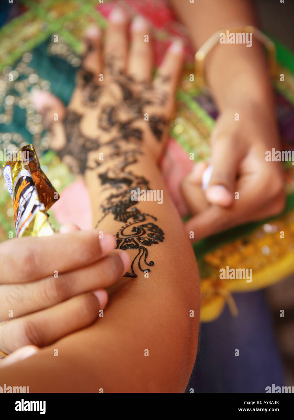 Close-up of a woman's hand l'application de tatouage au henné sur une autre femme. Banque D'Images