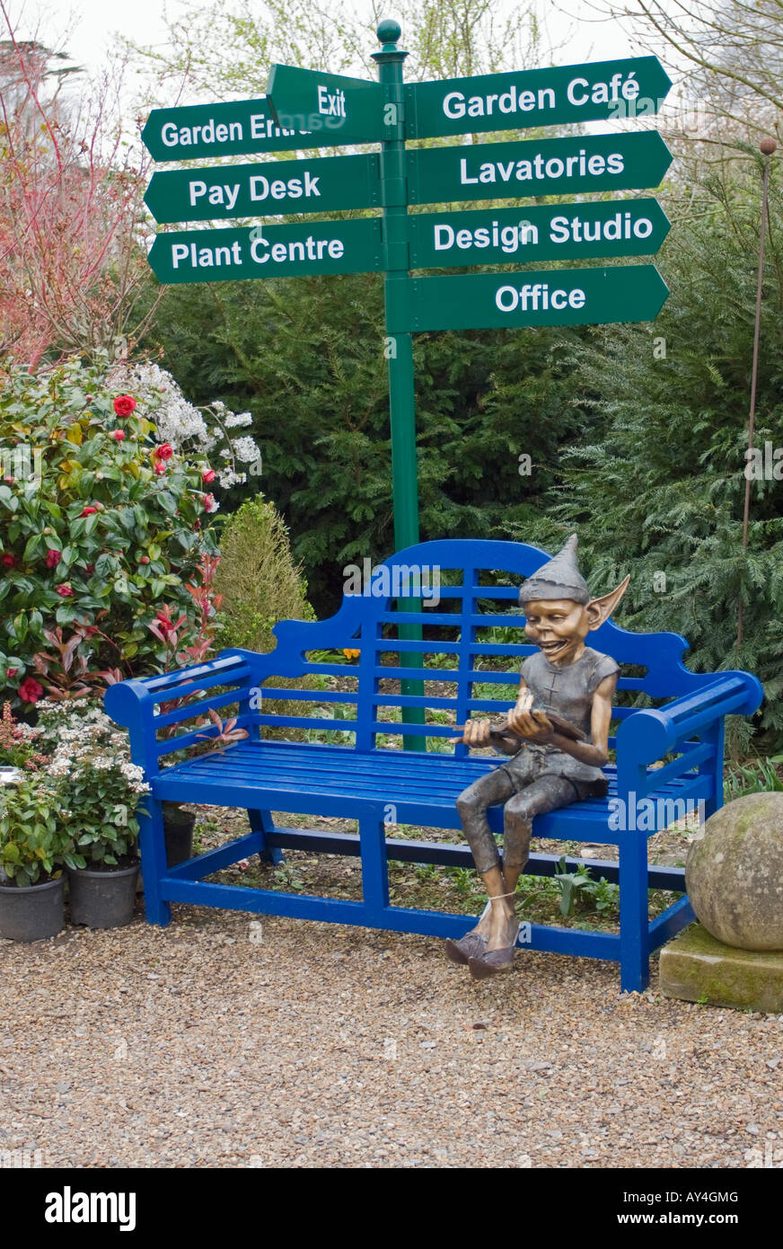 Lutin bleu assis sur le siège de jardin en bois Banque D'Images