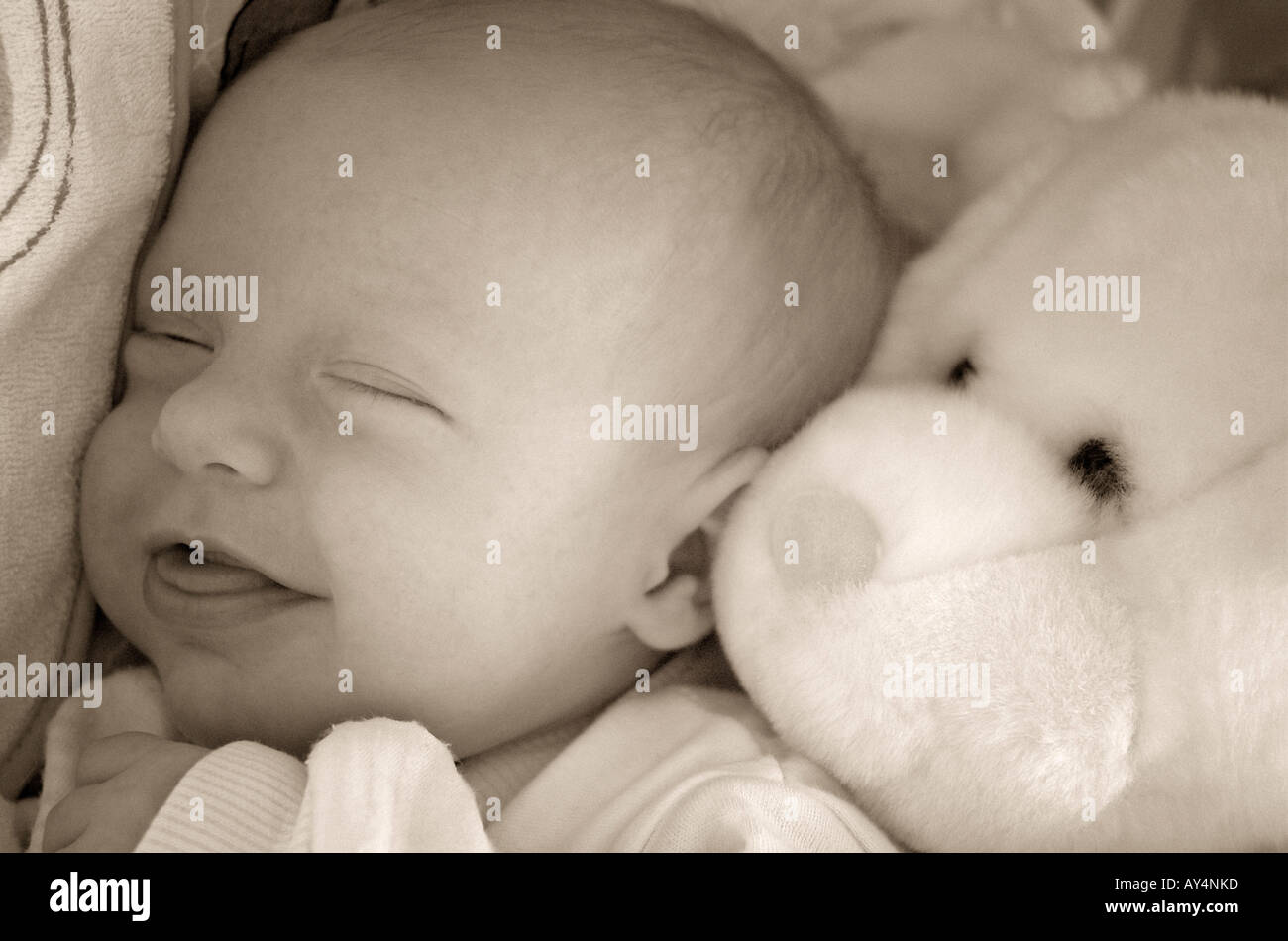 Image en noir et blanc de Naissance bebe Fille 03 mois tout en souriant elle est endormie près d'un visage Banque D'Images