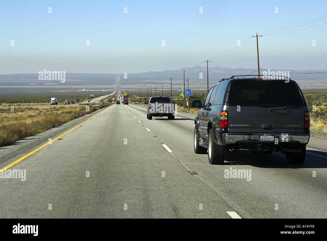 Vus et camions roulant sur la longue route droite à 2 voies I95 Nevada USA. Vue sur la longue route droite du désert s'étendant à l'horizon Banque D'Images