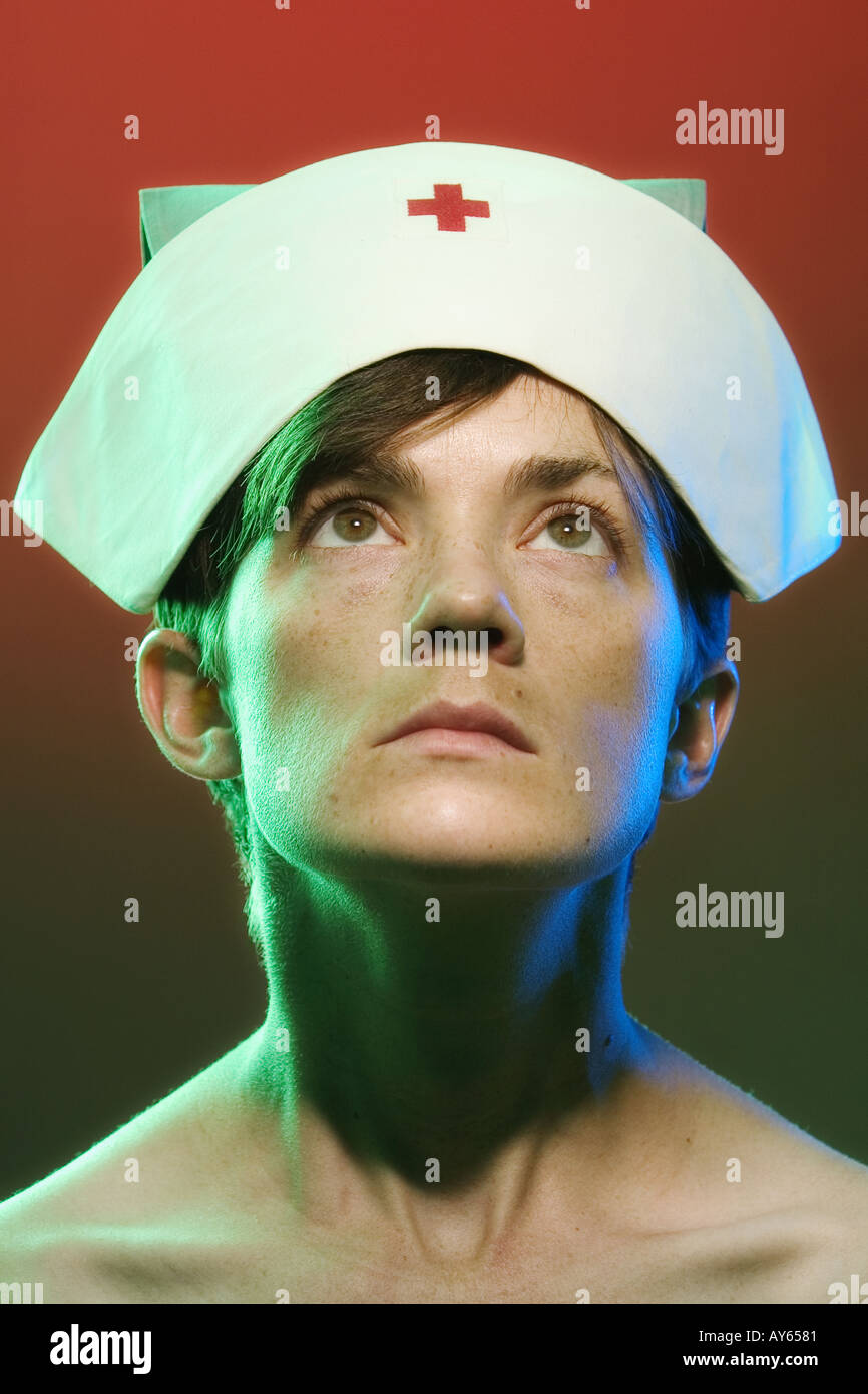 Portrait conceptuel serré d'une infirmière ou d'un illuminé par des lumières colorées scabreuses Banque D'Images