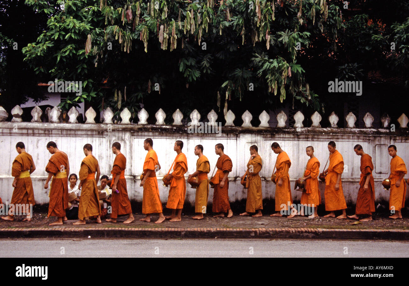 Ligne de moines recevant l'aumône dans les rues de Luang Prabang au Laos Banque D'Images