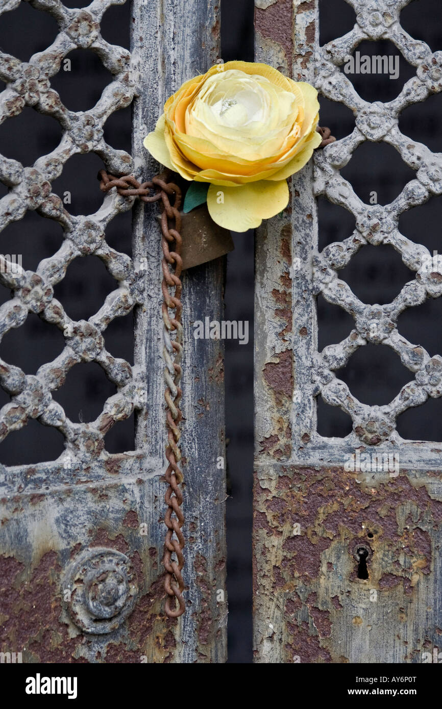 Une fleur en plastique décore la porte verrouillée d'un mausolée au cimetière de Montmartre. Banque D'Images