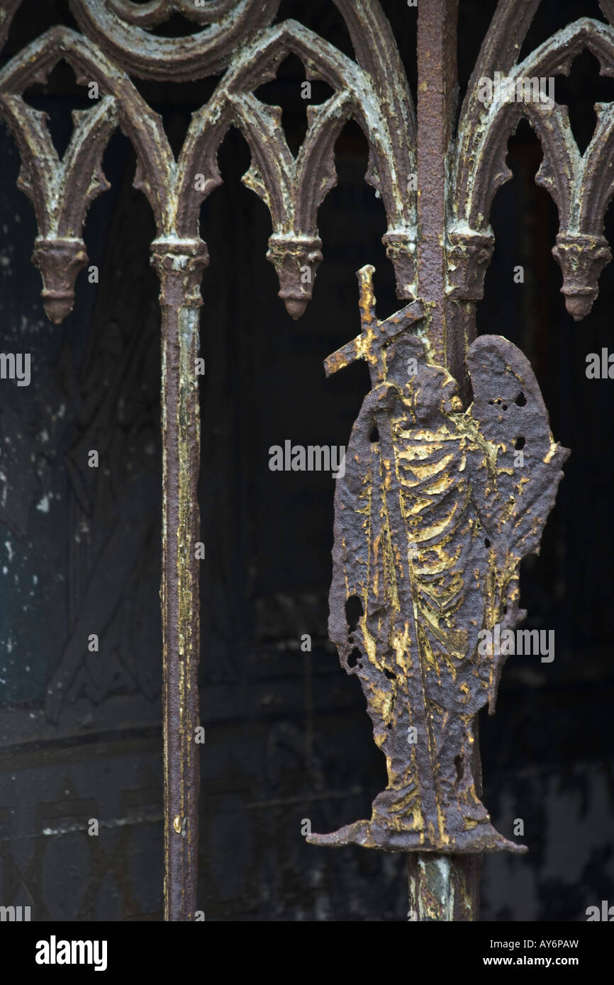 Un ange avec des traces de dorures ornent la porte d'un mausolée au cimetière Montmartre, Paris Banque D'Images