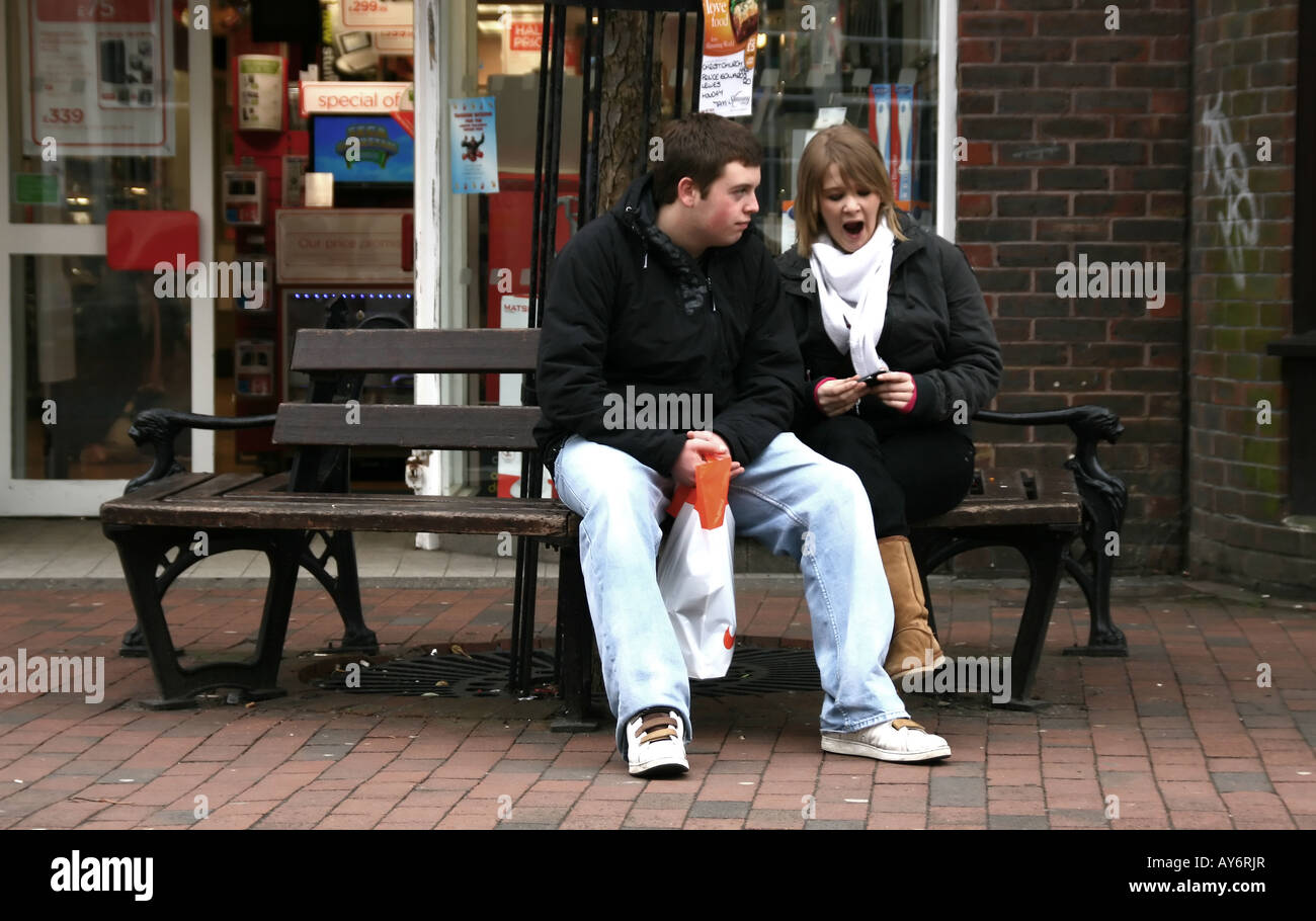Résidence typique de la couple assis sur un banc, d'avoir une pause de shopping Banque D'Images