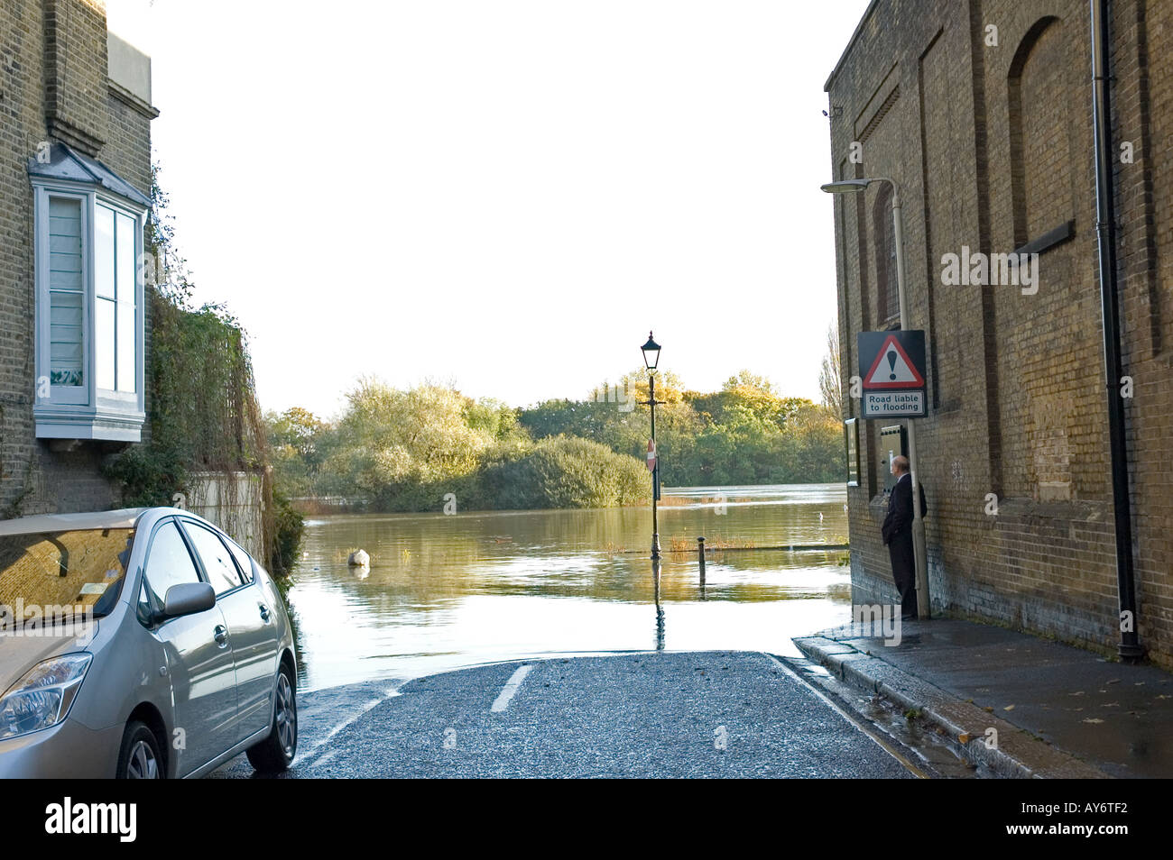 Marées inondations road que l'homme regarde sur Chiswick Mall Londres Banque D'Images