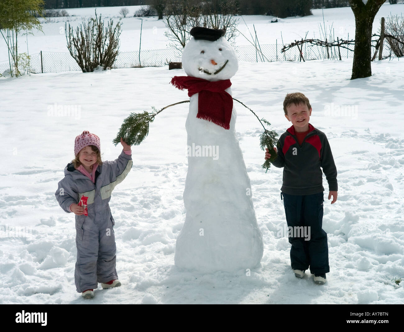 Les enfants avec le Snowman Banque D'Images