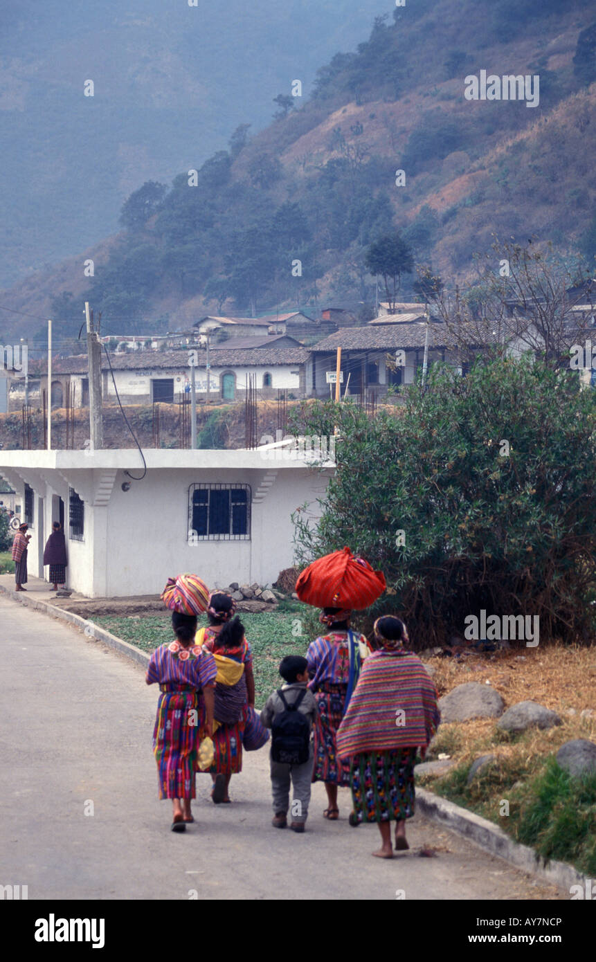 Les femmes mayas et les enfants marcher dans une rue dans le village de Zunil, près de la ville de Quetzaltenango, Guatemala Banque D'Images