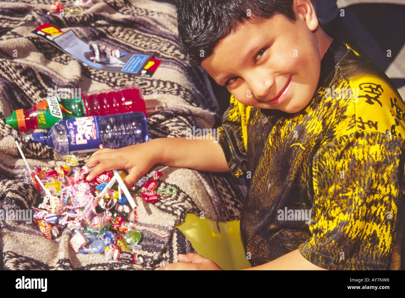 Un jeune garçon hispanique est heureux avec tous ses bonbons et réception des prix à la parade au centre-ville de Las Vegas, Nouveau Mexique. Banque D'Images